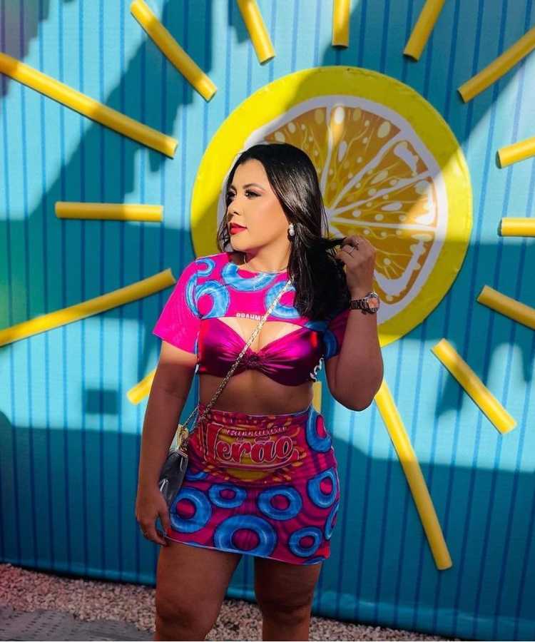Mulher usando abadá personalizado de Carnaval em forma de saia, com top rosa metalizado e outra parte do abadá de cropped