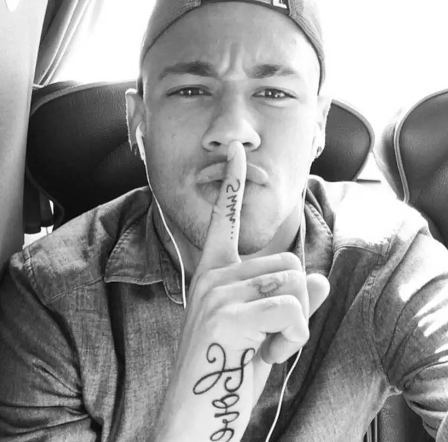 Foto de Neymar Júnior fazendo símbolo de silêncio com a mão