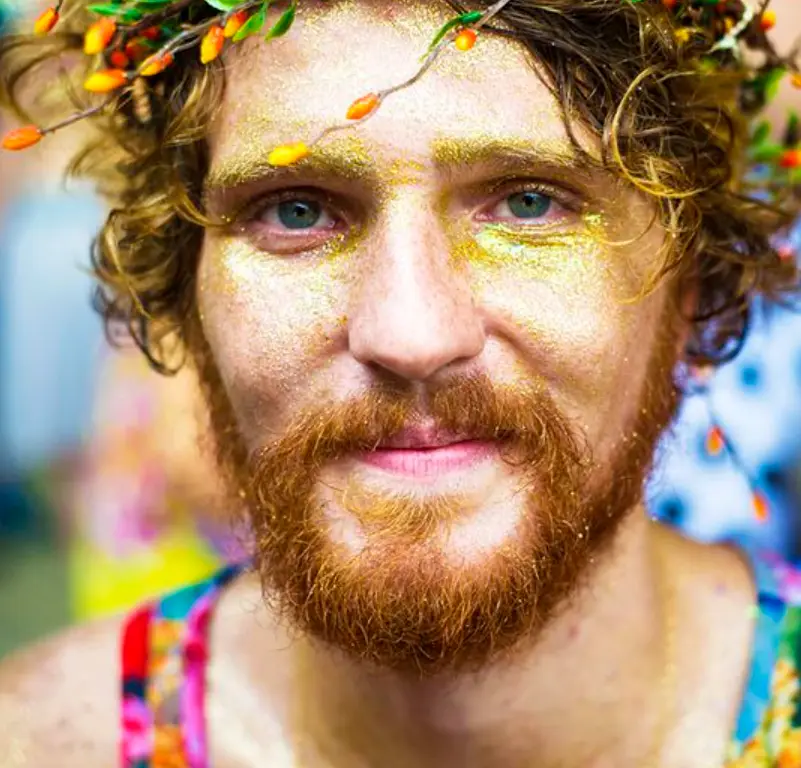 Homem de pele clara com rosto de glitter dourado