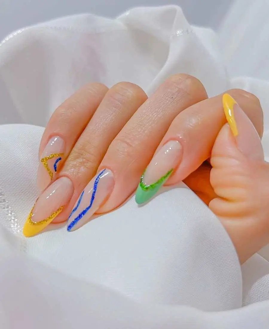 Imagem de mão decoradas com esmalte. Cores usadas, verde, amarelo e azul. Deocoradas com glitter azul, amarelo e verde. Arte, francesinha. 
