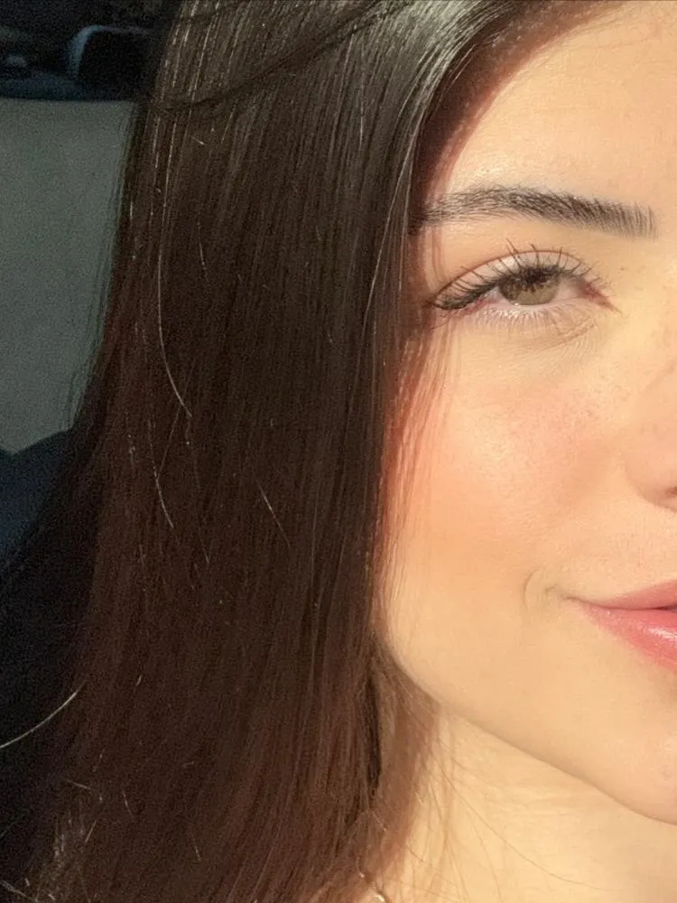 Selfie de muher de pele clara com corte, mostrando apenas parte do cabelo, um olho e metade da boca 
