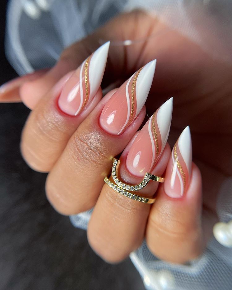 Unhas em gel com glitter dourado e decoração branca (tamanho: extra grande. Formato: stiletto) 