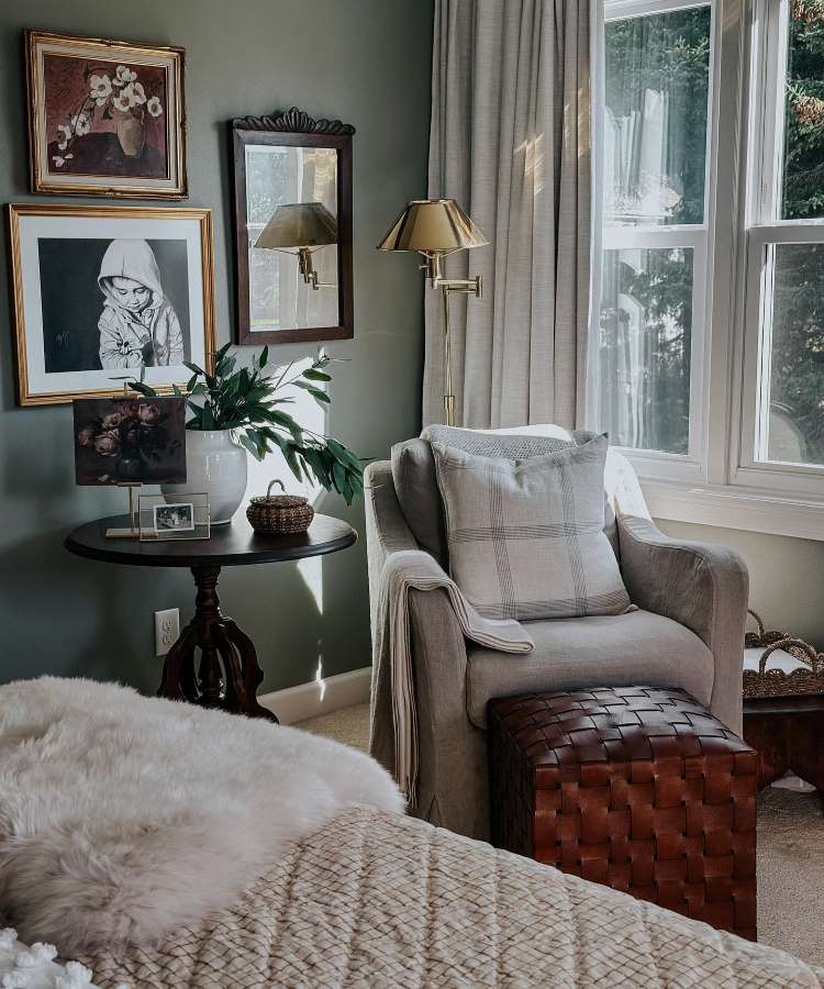 Quarto com espelho pequeno emoldurado de madeira na parede. Cores predominantes: verde, cinza, madeira envernizada, dourado
