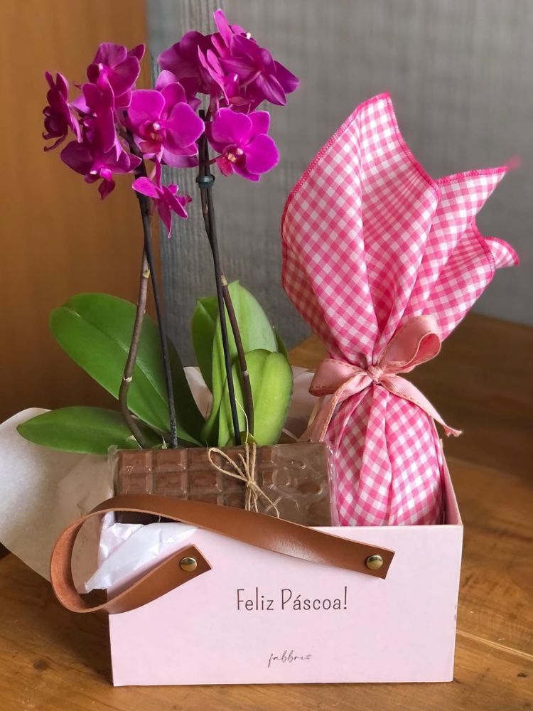Cesto rosa com ovo de Páscoa, tablete de chocolate e flores rosas 