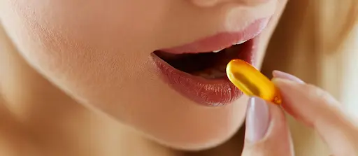 Mulher segurando uma capsula de óleo de prímula para ingerir