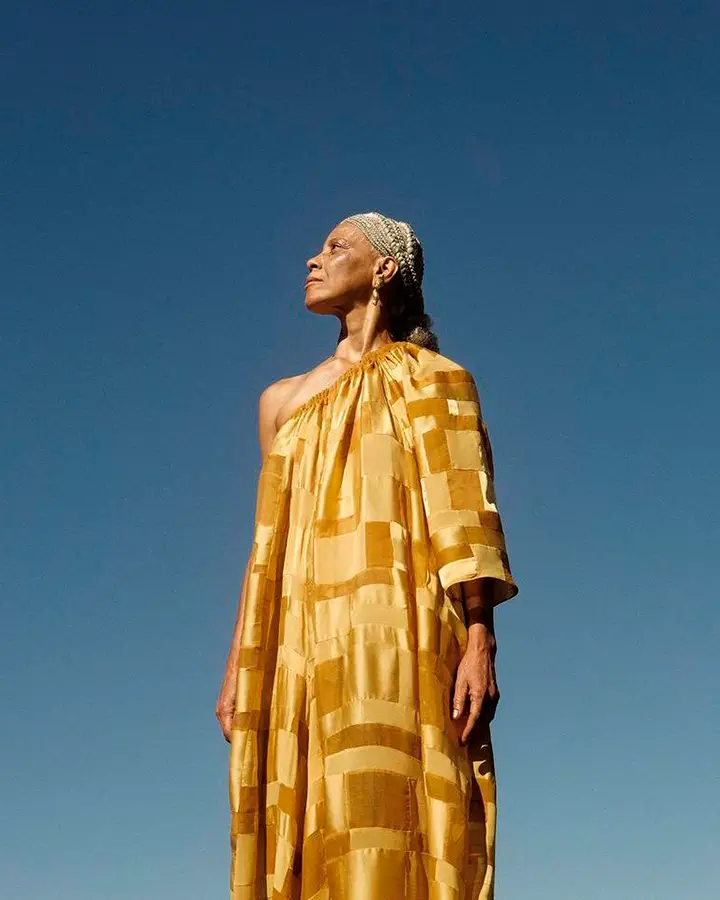 Modelo usa um vestido amarelo longo.