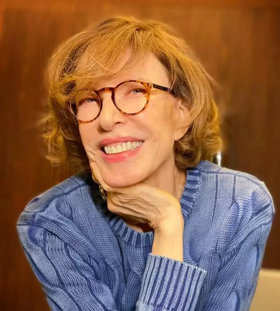 Marília Gabriela sorrindo em foto com foco no rosto. Apresentadora está com a mão nos queixos - famosas mais 70 anos.