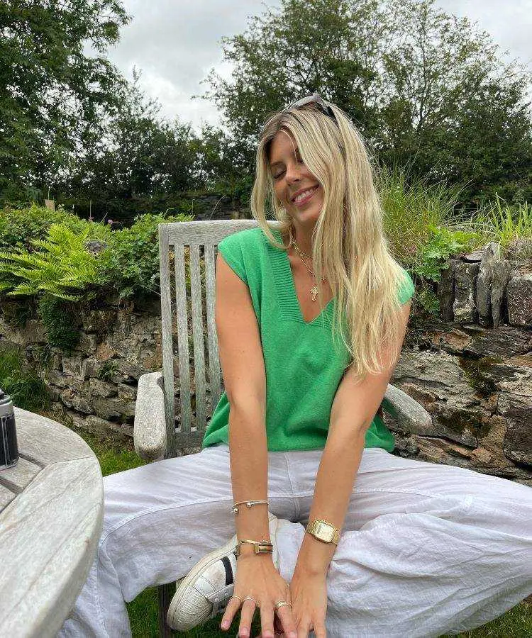 Colete verde, calça branca e tênis da adidas