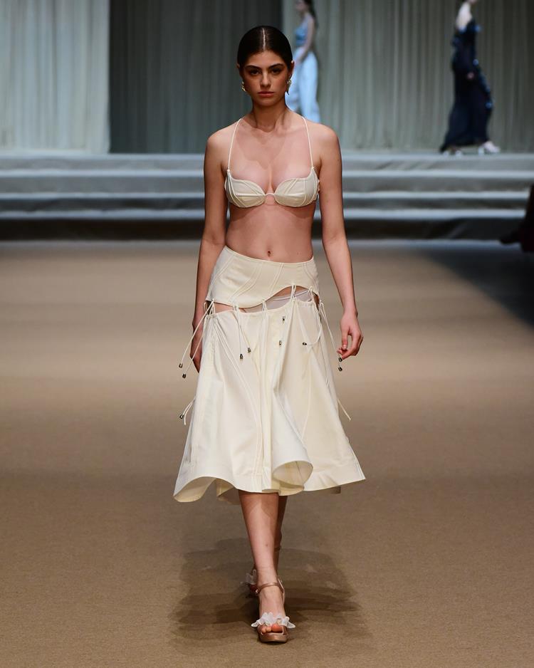 modelo com conjunto de top e saia brancos.