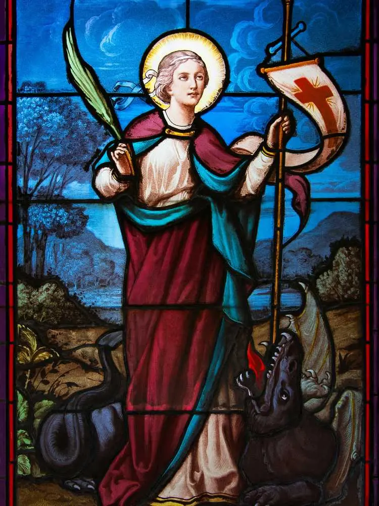 Imagem de vitral com fundo azul, São Jorge com lança e dragão