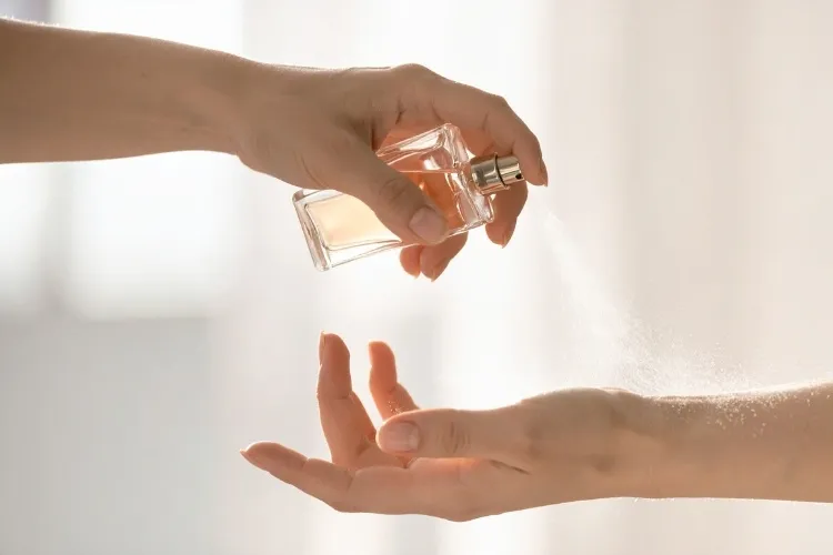Pessoa aplicando perfume para o verão no pulso