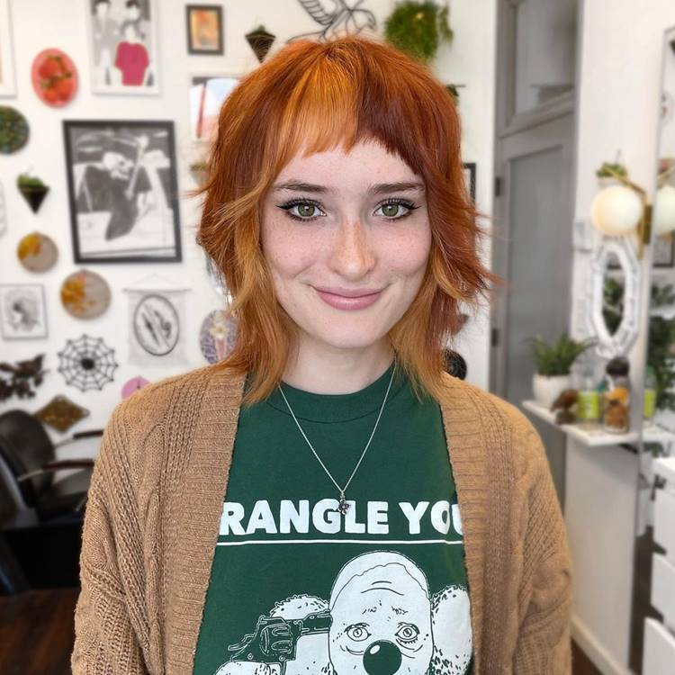Mulher ruiva com franja baby bangs