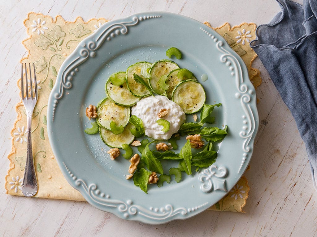 Carpaccio de abobrinha em prato sobre mesa