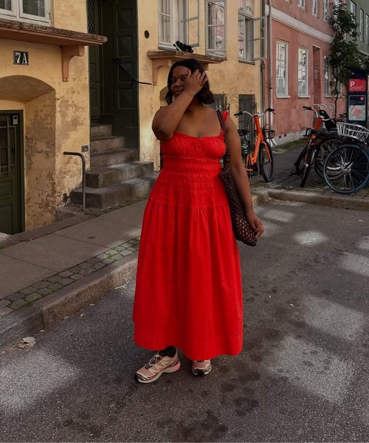 Foto de mulher usando vestido mídi vermelho com tênis e bolsa de macramê