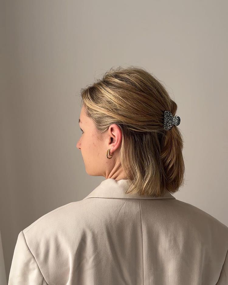 mulher com cabelo loiro semipreso com presilha pequena