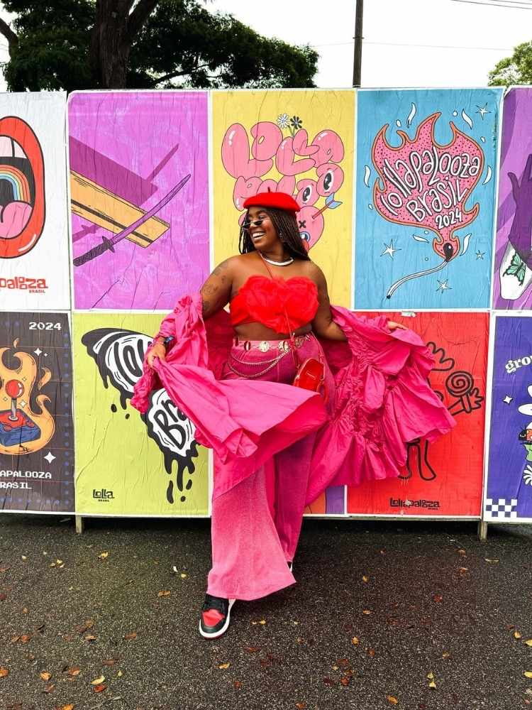 Mari Lobo usando top vermelho em formato de coração, calça rosa, cardigan rosa, boina, acessórios