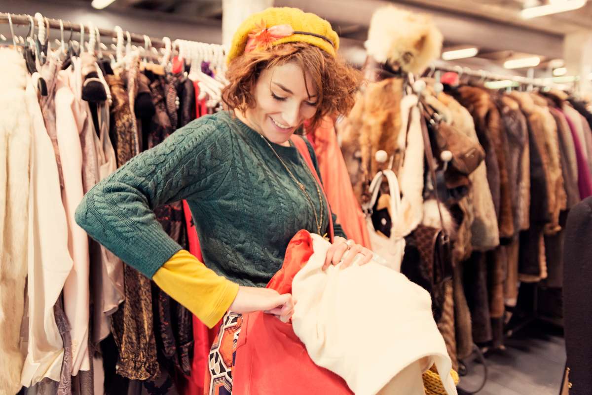 mulher comprando roupas no brechó