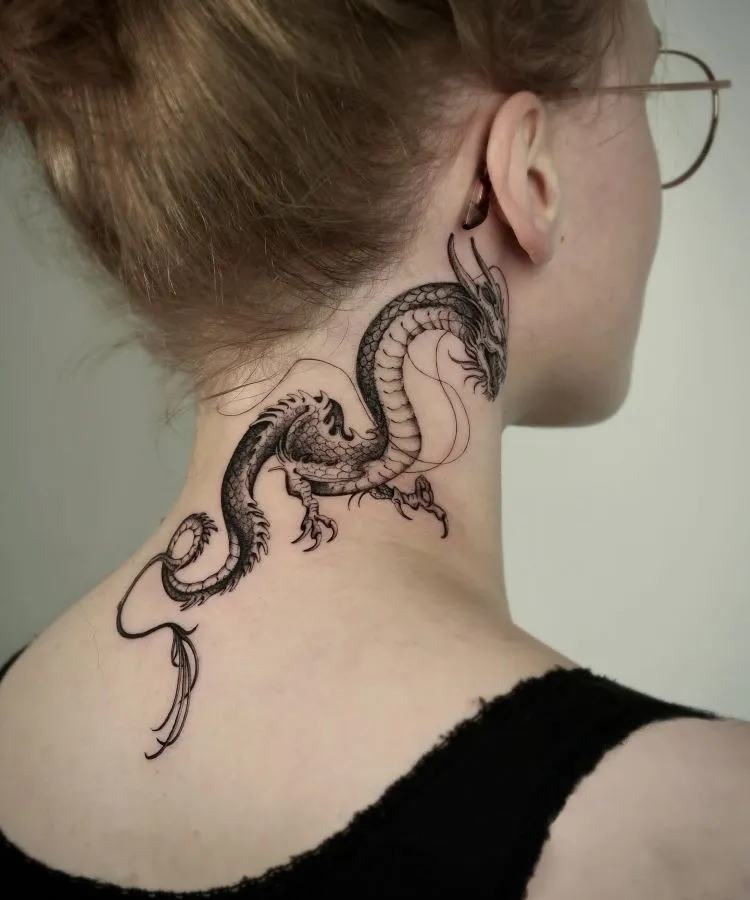 A imagem mostra uma pessoa de perfil com cabelo preso e óculos. Ela tem uma tatuagem no pescoço de um dragão detalhado em preto, que se estende da parte de trás da orelha até a base do pescoço. A tatuagem é intrincada, com escamas e garras bem definidas.


