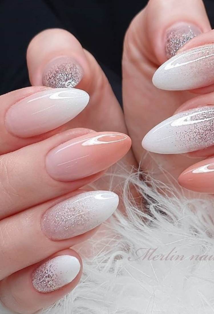 Unha almond em nude e outras em branco com glitter