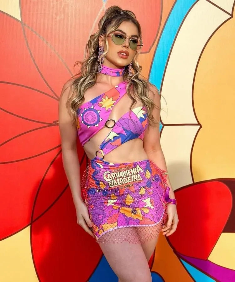 Foto de mulher loira usando vestido feito com abadá e argolas de metal