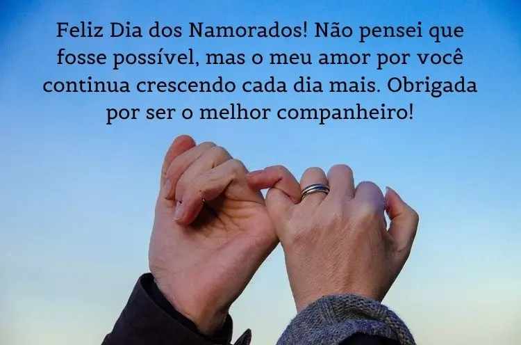 Foto de pessoas de pele clara com dedinhos entrelaçados e frase "Feliz Dia dos Namorados! Não pensei que fosse possível, mas o meu amor por você continua crescendo cada dia mais. Obrigado (a) por ser o (a) melhor companheiro (a)!"