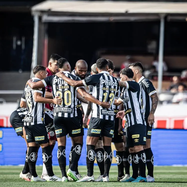 Elenco do Santos com o segundo uniforme se abraçando em campo. 
