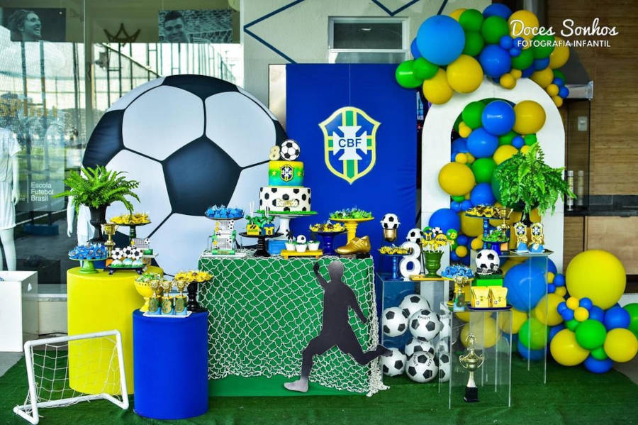 Decoração com bolo de três andares e de futebol.