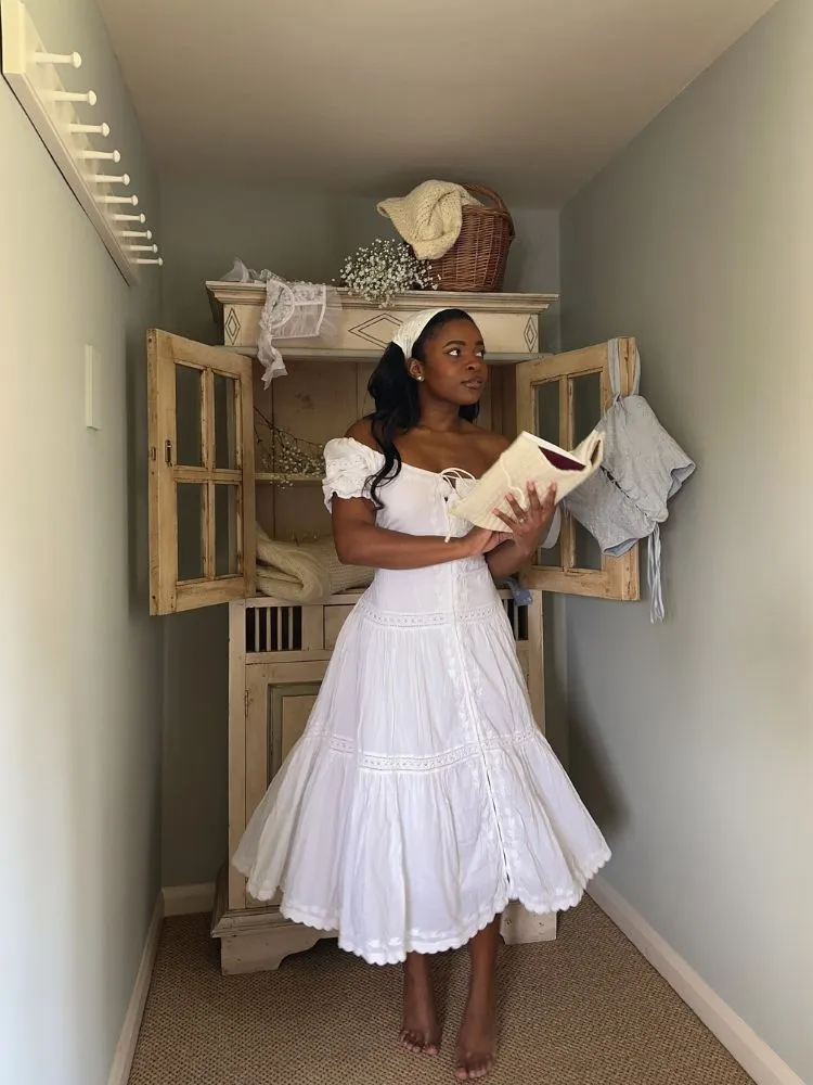 Mulher de pele negra com vestido cottage branco 