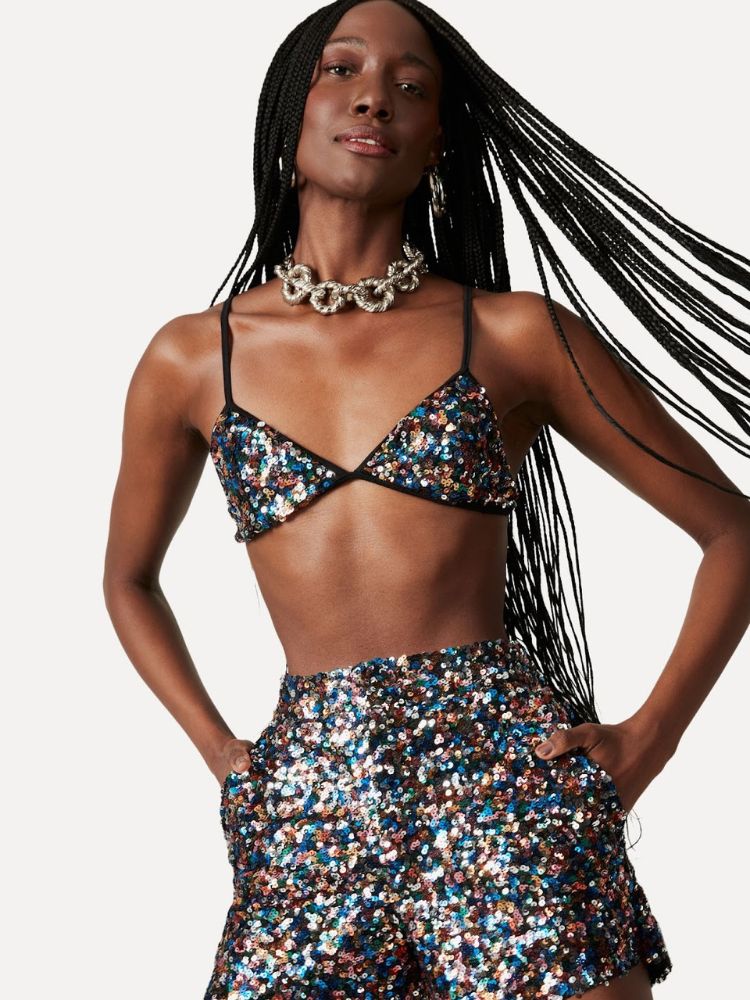 Mulher de pele negra usando top e shorts de lantejoulas furtacor