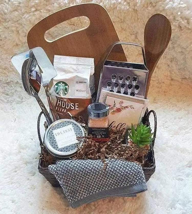 Cesta de Natal com utensílios domésticos como colheres, tábua e ralador, além de sal, planta e mais 