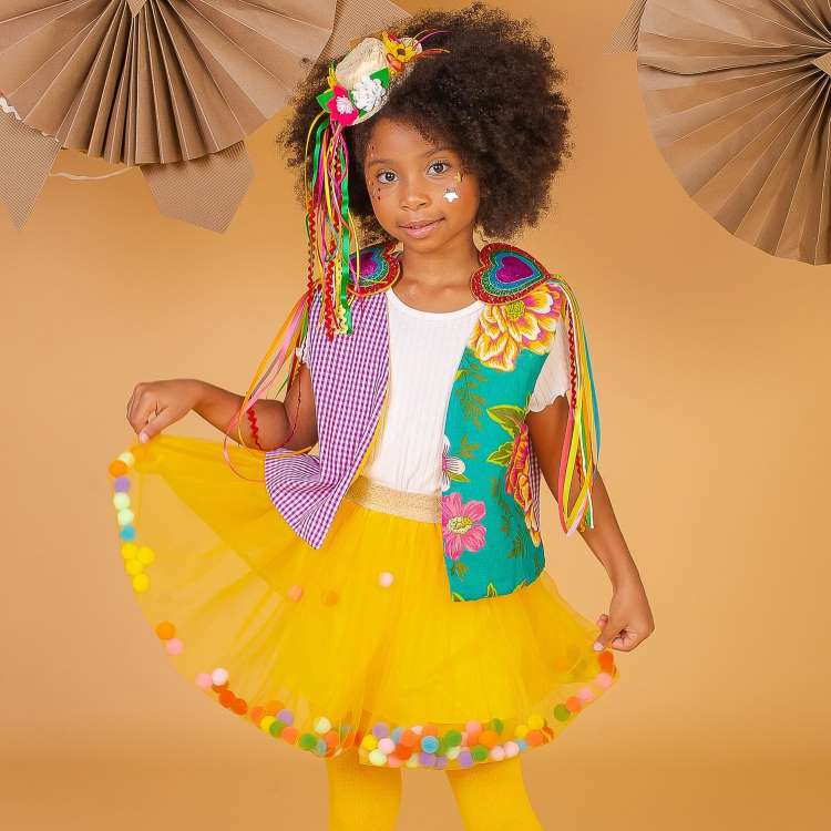 Menina com saia de tule amarela, colete para look junino