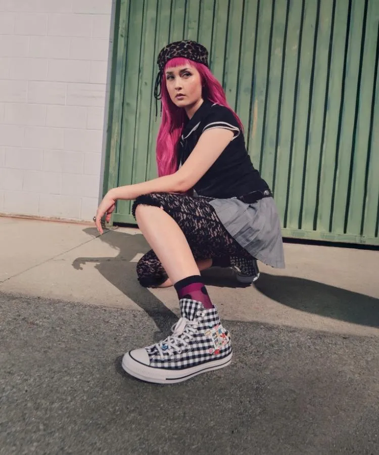 Foto de modelo de cabelo rosa usando tênis da collab Converse x Hello Kitty® And Friends