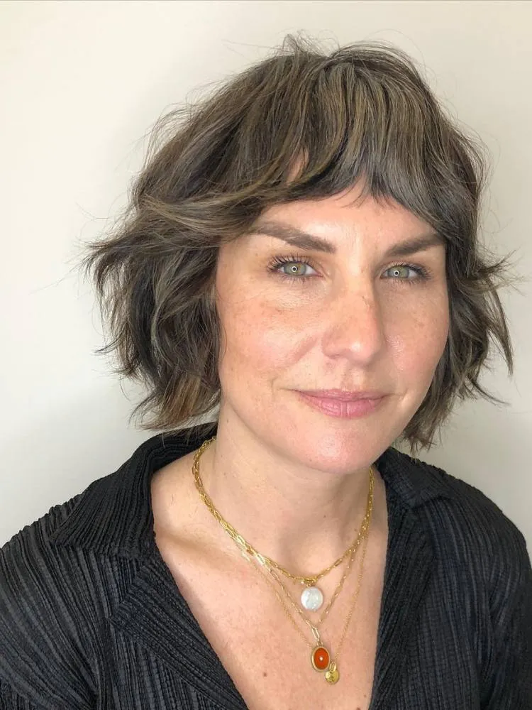 Mulher com cabelo curto castanho-claro repicado
