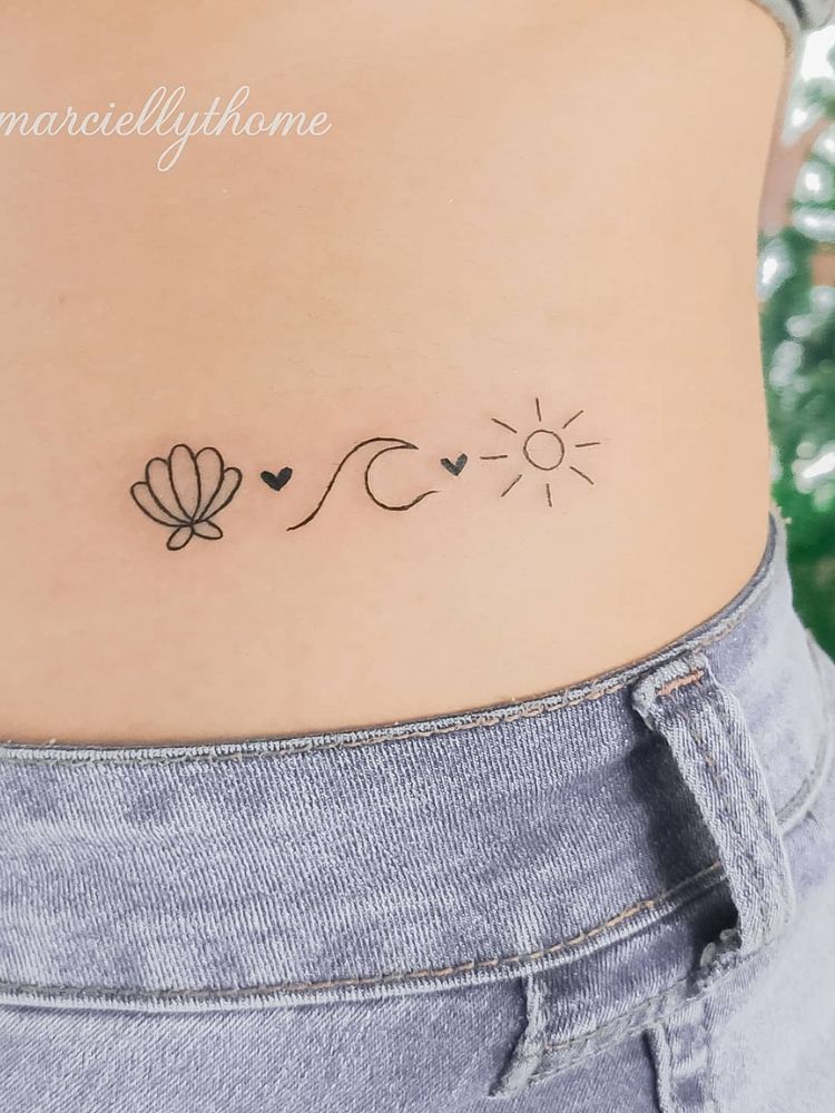 Cintura tatuada com concha, onda e sol em fineline