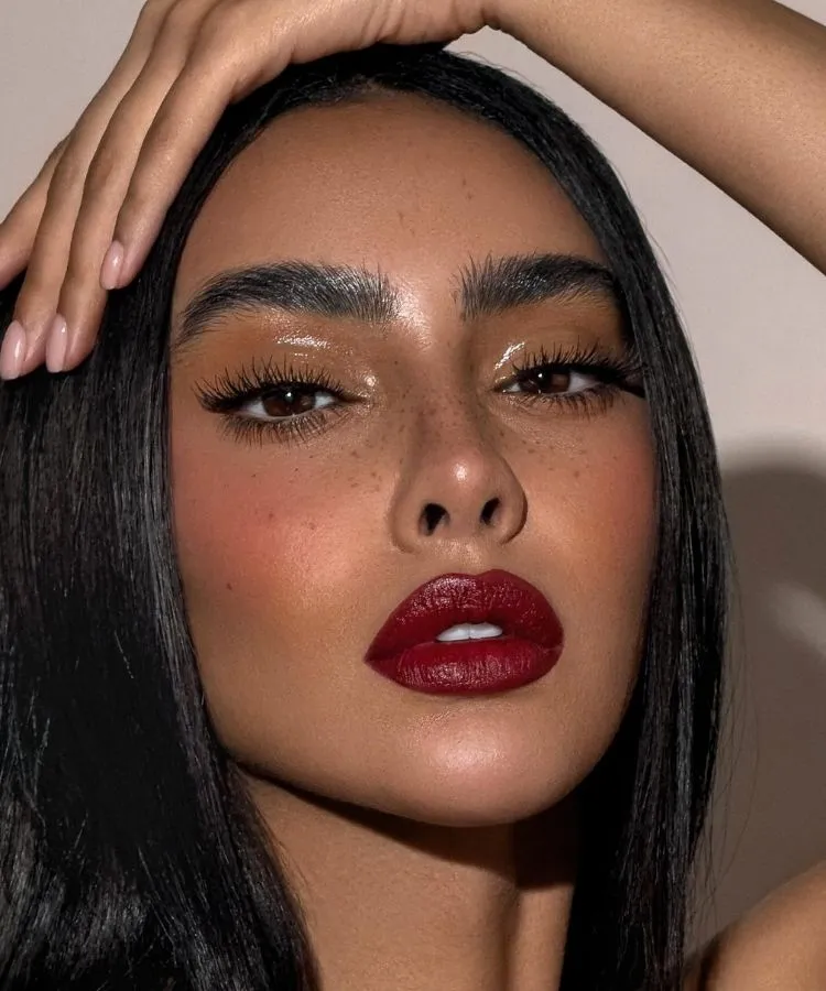 Foto de mulher de pele morena usando batom vermelho