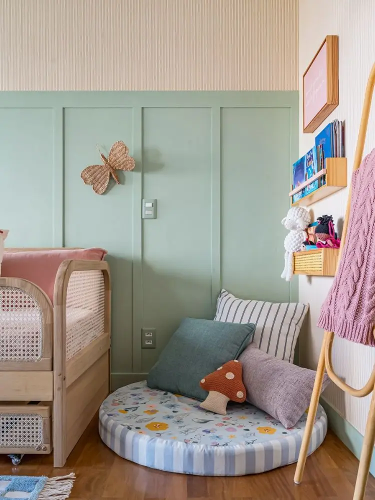 Zoom em canto do quarto com cama, parede verde, almofadas e cogumelo e ovelha de amigurumi