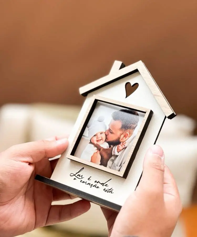 A quarta imagem mostra um porta-retrato de madeira em formato de casa, com um coração vazado no telhado. Dentro do quadro, há uma foto de um pai beijando seu bebê. Na base, a frase "Lar é onde o coração está" está escrita.







