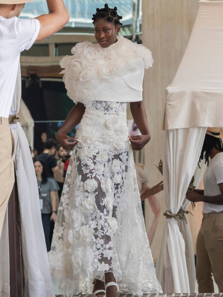 Mulher de pele negra usando vestido de noiva com flores e saia transparente