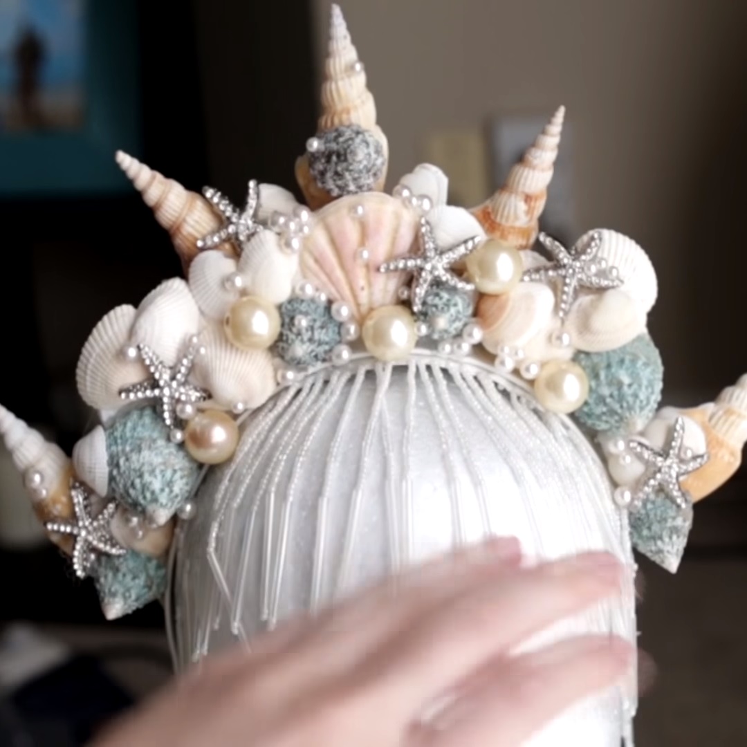 Foto de coroa de sereia com estrelas do mar de strass, conchas e pérolas