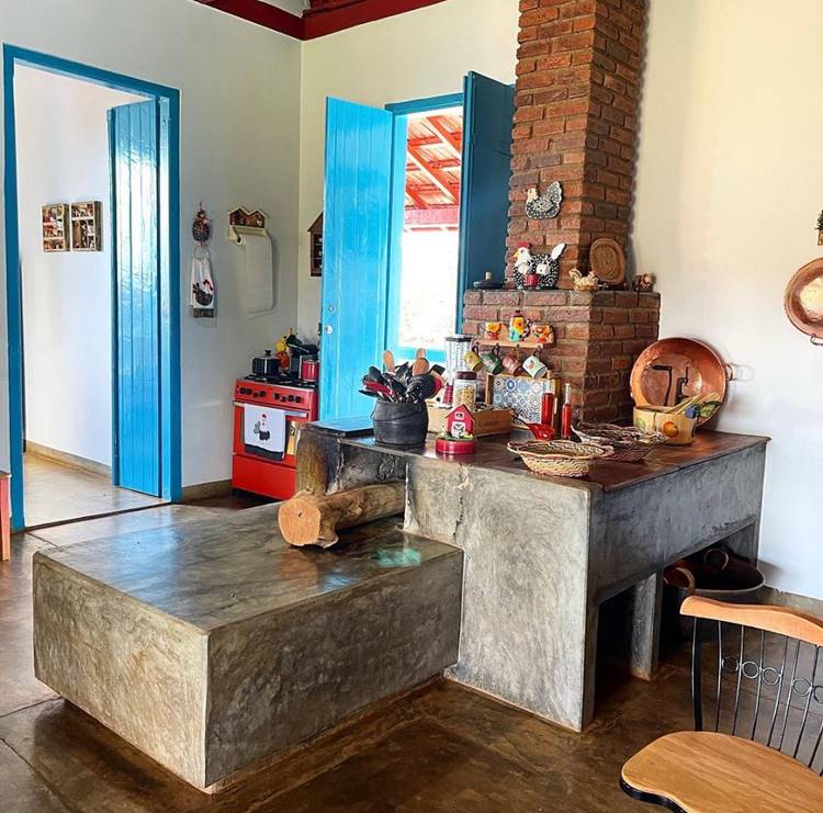 Fogão à lenha decorado com panelas de ferros, talheres, canecas, bacia de cobre, etc