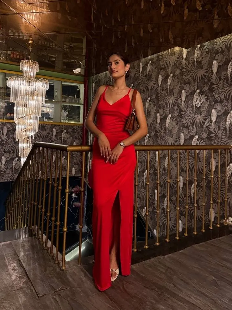 Mulher indiana usando vestido slim vermelho com sandália de salto, bolsa, relógio e acessórios discretos 