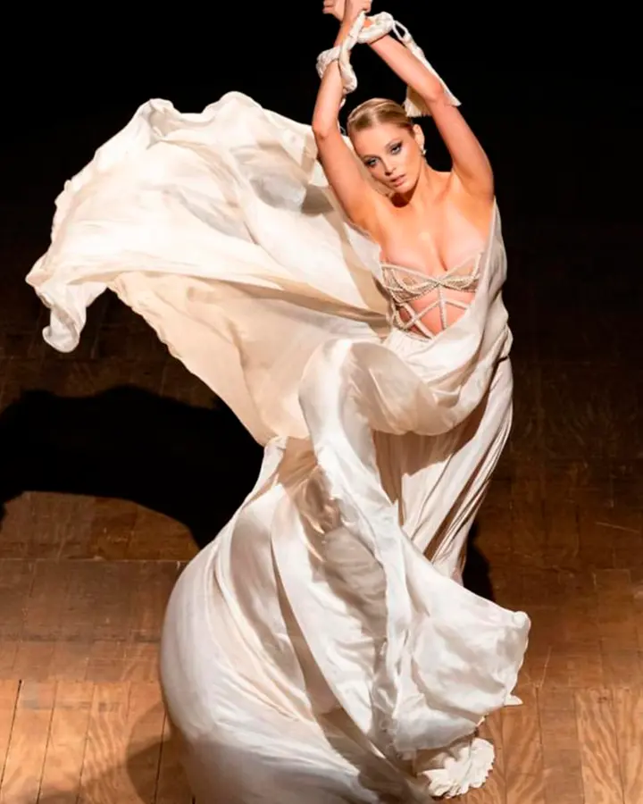 Modelo com vestido esvoaçante branco.