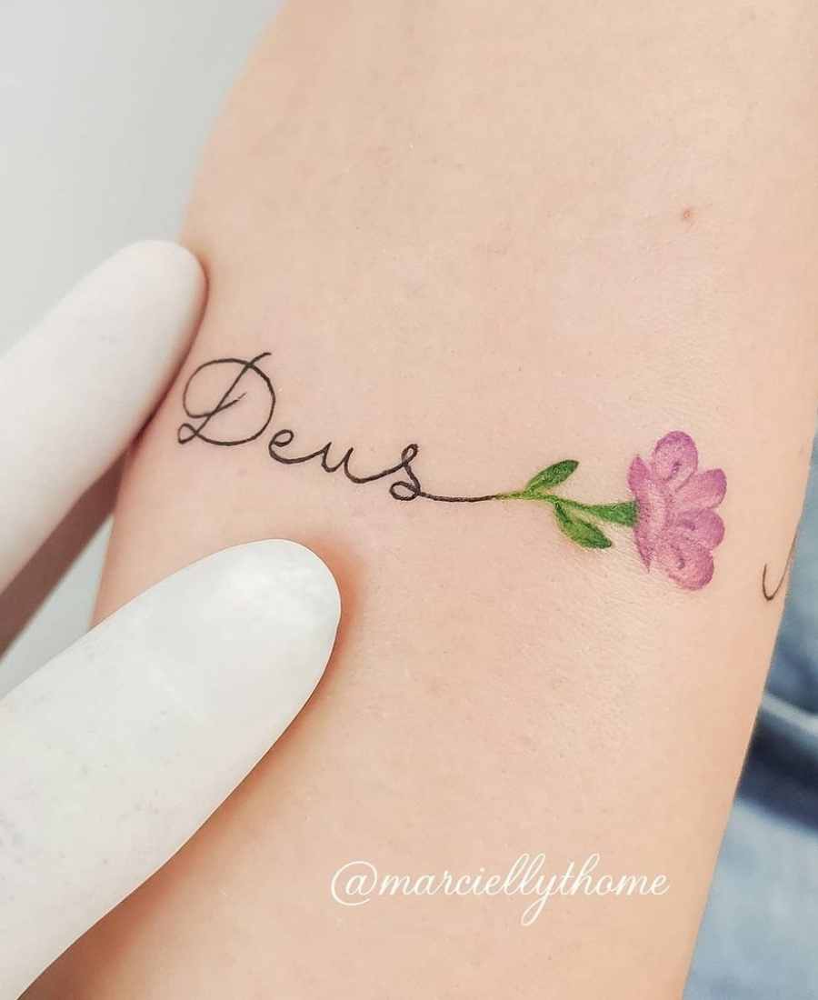 Foto defoto de tatuagem religiosa com nome de Deus de uma pessoa.