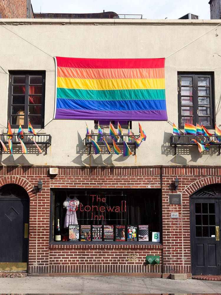 Fachada de Bar Stonewall inn, com tijolos à vista e bandeiras LGBT