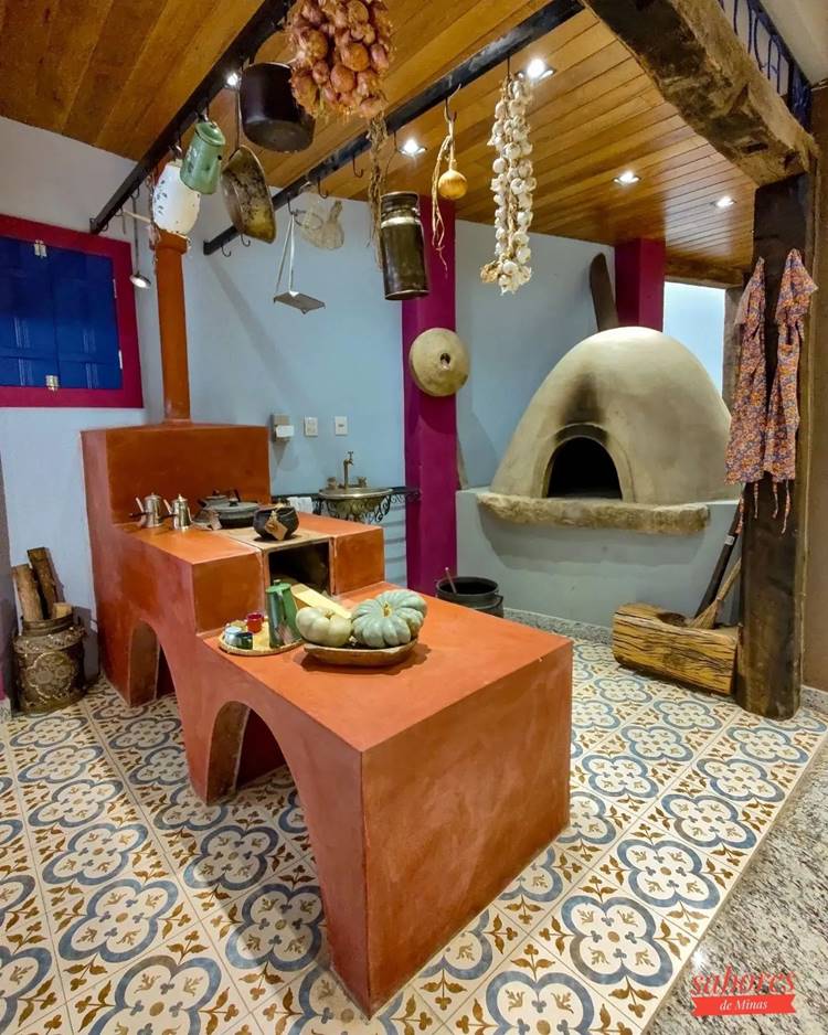 Fogão à lenha decorado com cesta com abóboras, panelas de ferro, bule