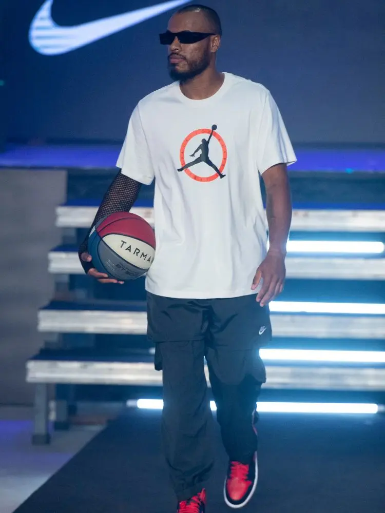 modelo no desfile do Studio 78 usando peças da Nike e com uma bola de basquete. 