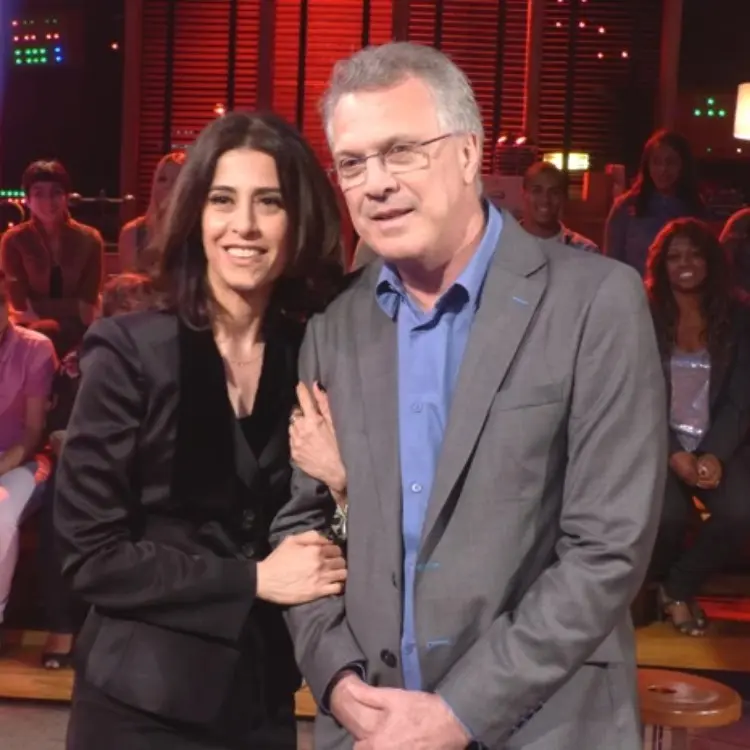Fernanda Torres de look preto abraçada com Pedro Bial de terno cinza e camisa azul no palco do "Na Moral"