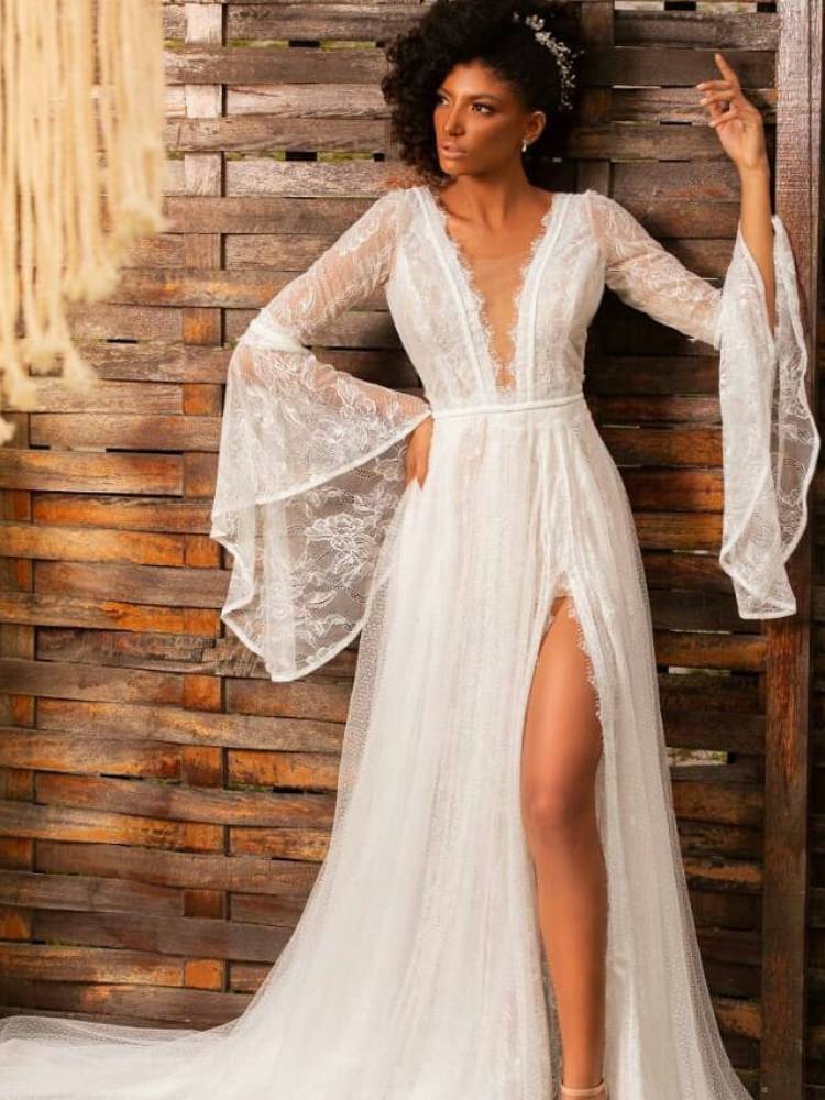 Mulher de pele negra usando presilha prateada e vestido boho decotado, com mangas longas e fenda na perna