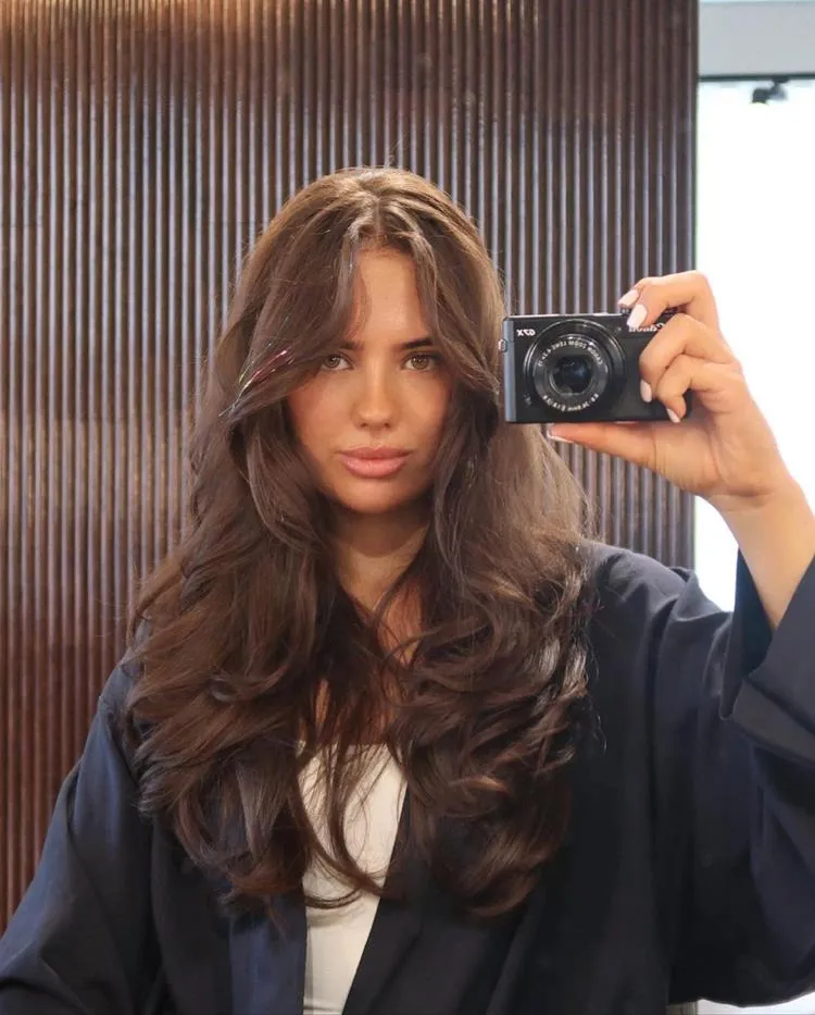 mulher com cabelo longo castanho e franja média