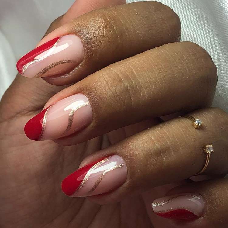 Unhas vermelhas decoradas com ondas douradas